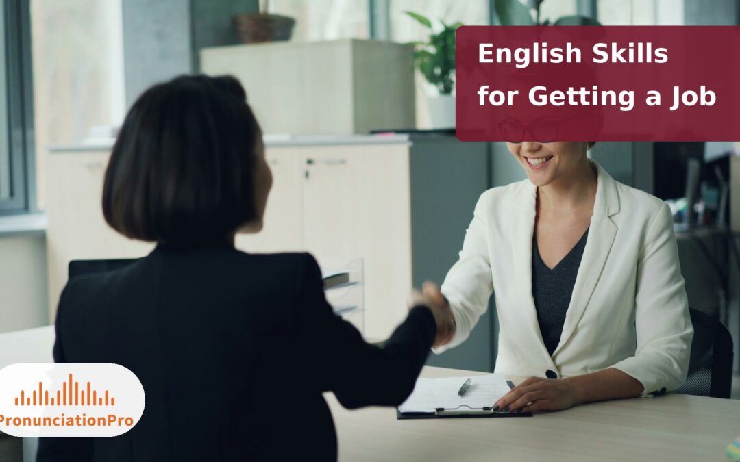 Two women shaking hands across a desk at a job interview