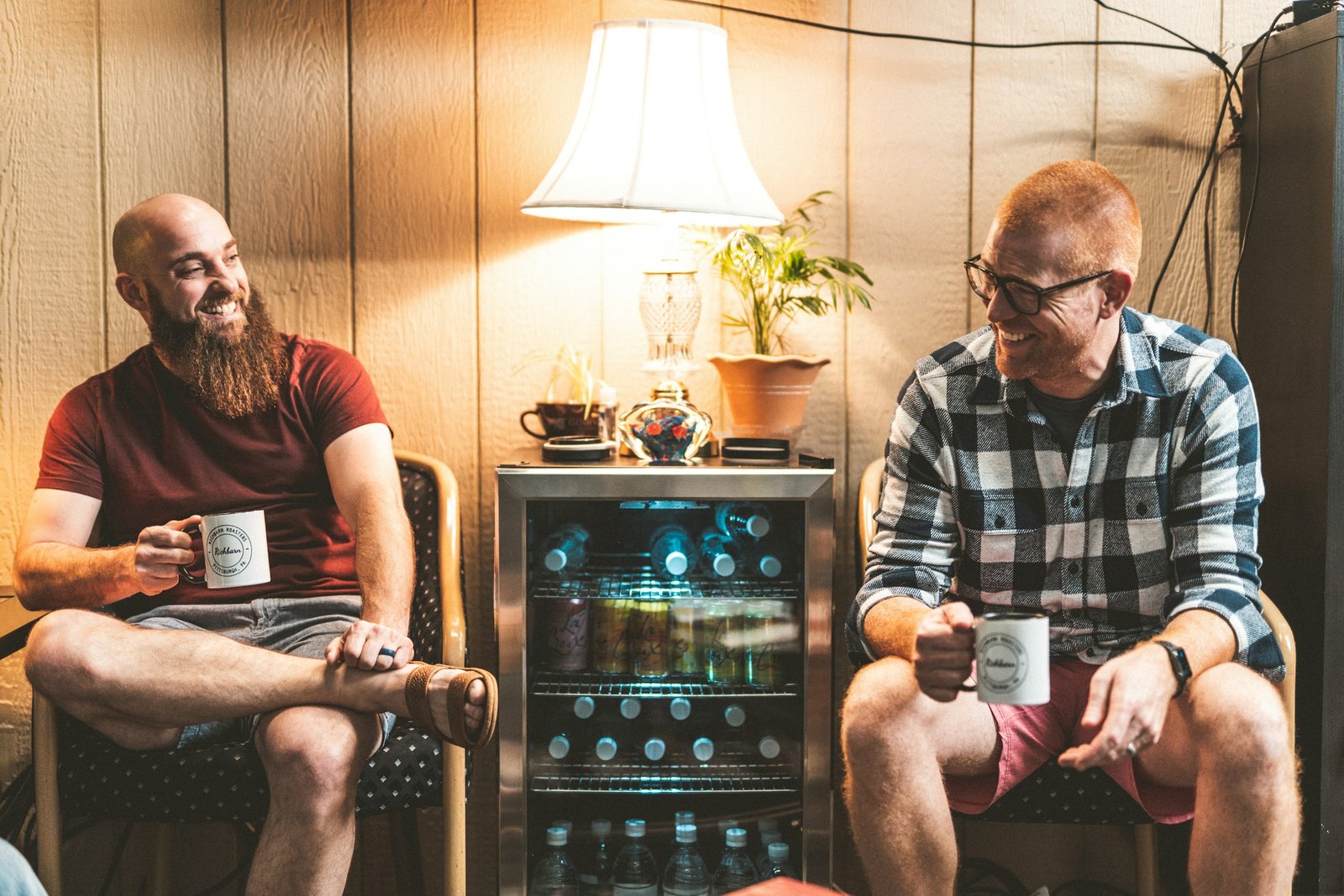 Two men chatting over coffee in a cozy living room